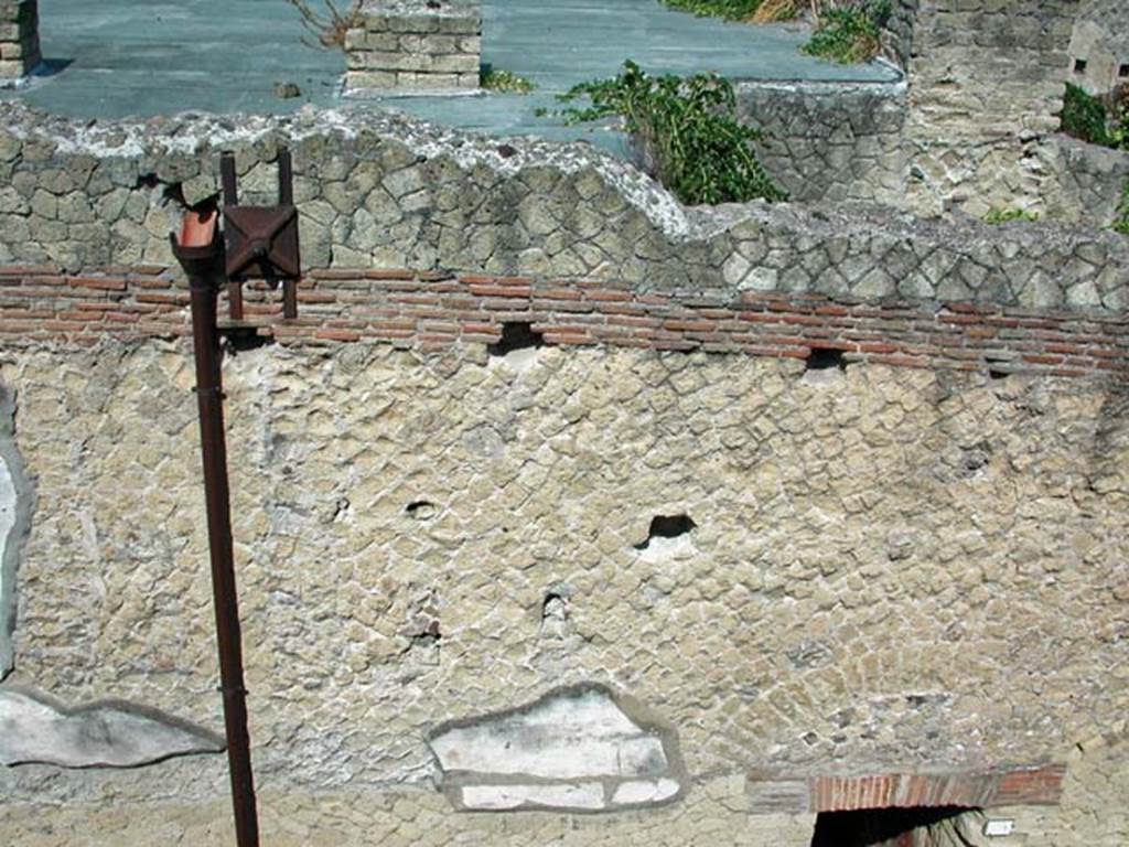 VI.9, Herculaneum. September 2003.
Looking west to detail of upper facade, and roof area originally attics and terraces, above entrance doorway.Photo courtesy of Nicolas Monteix.